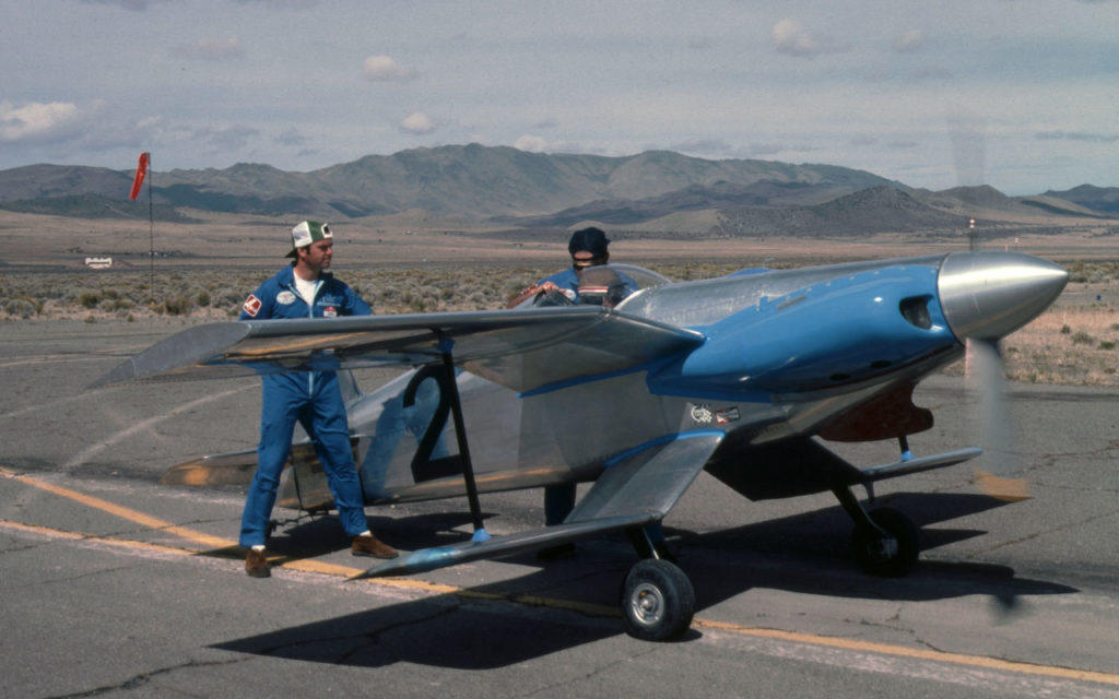 Two men holding the Eureka Cobra Biplane while testing engine.